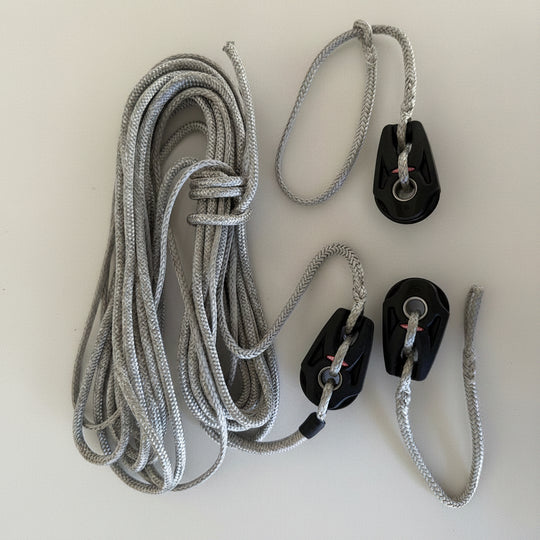 Gray rope with black pulley system on a white background